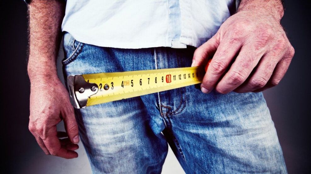 Mann misst Penis nach Vergrößerung mit Gel.